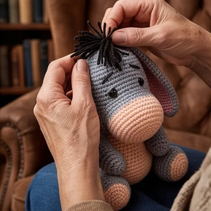 Crocheter adjusting the mane of the finished donkey